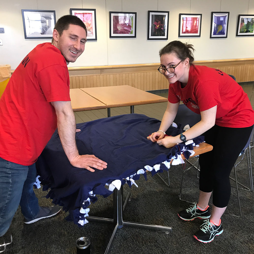 The UConn Cares alumni group assemble no-sew blankets with inspirational cards tucked inside for UConn Health cancer patients on April 28, 2018. (Wanita Thorpe/UConn Health photo)